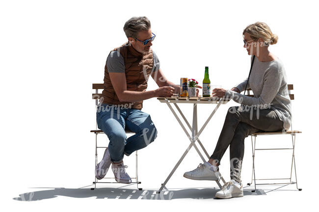 backlit man and woman sitting in an outdoor restaurant