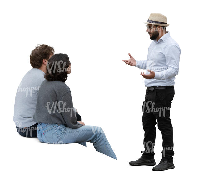 man standing and talking to two people sitting