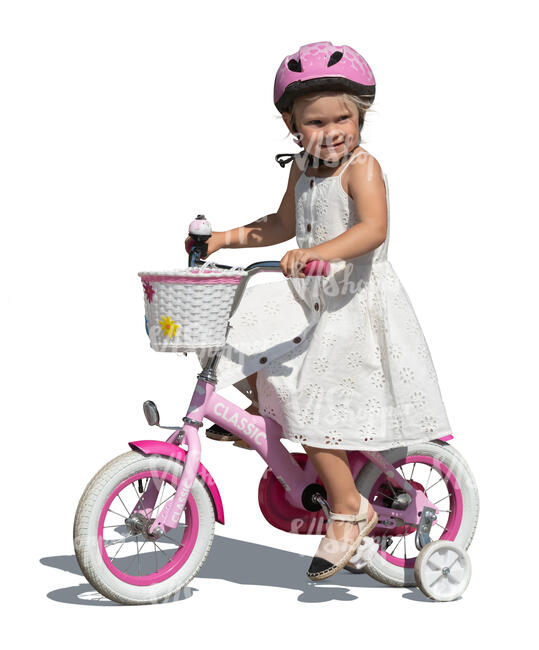 little girl in a white dress riding a bike