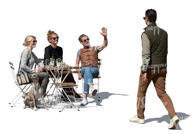 group of friends in a cafe greeting a man walking by