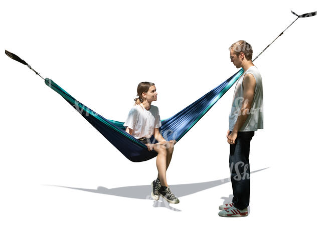 woman sitting in a hammock under a tree and talking to a guy