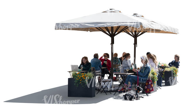 backlit street cafe with parasols and people