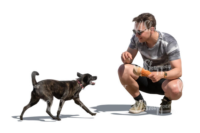 man squatting and playing with his dog