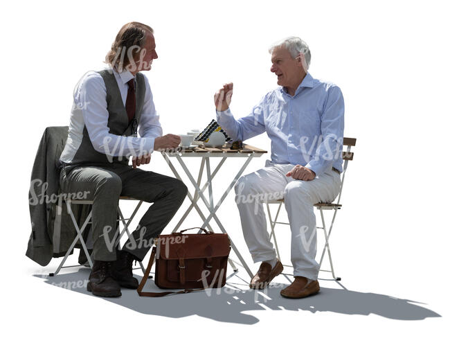 two backlit men sitting in a cafe