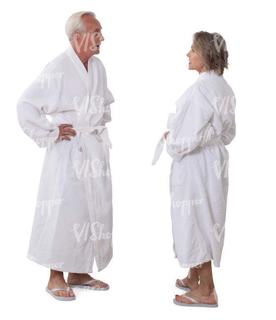 senior man and woman in white bathrobes standing and talking