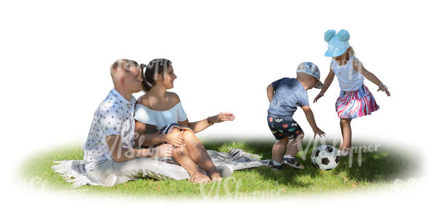 family with kids sitting on the grass in the tree shade