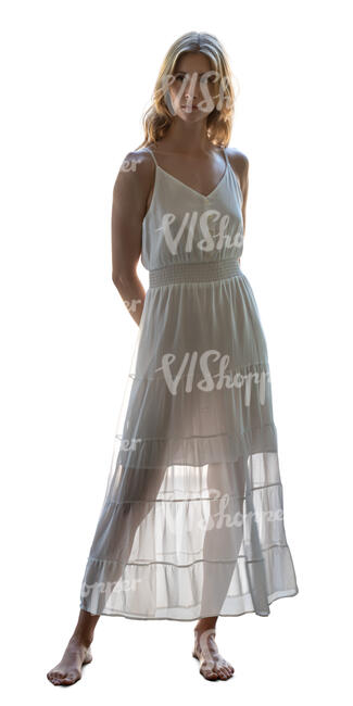 backlit woman in white summer dress standing barefoot
