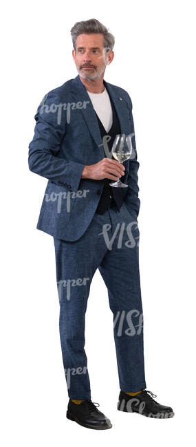 man in a suit standing and drinking wine