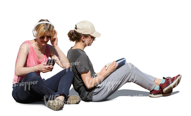 two people sitting on the ground and reading