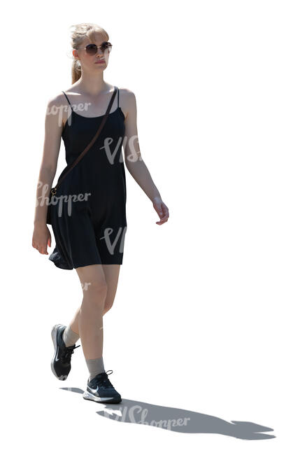 backlit woman in a black mini dress walking