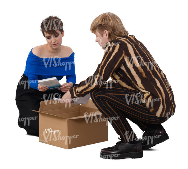 two people squatting and taking books out from a box