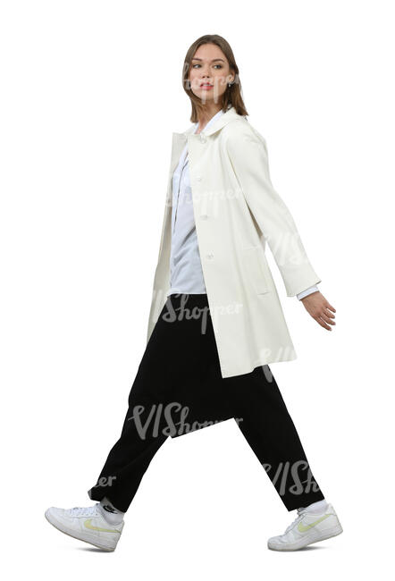 woman in a white coat walking hastily