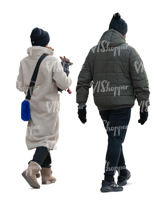 man and woman with a little dog walking in winter