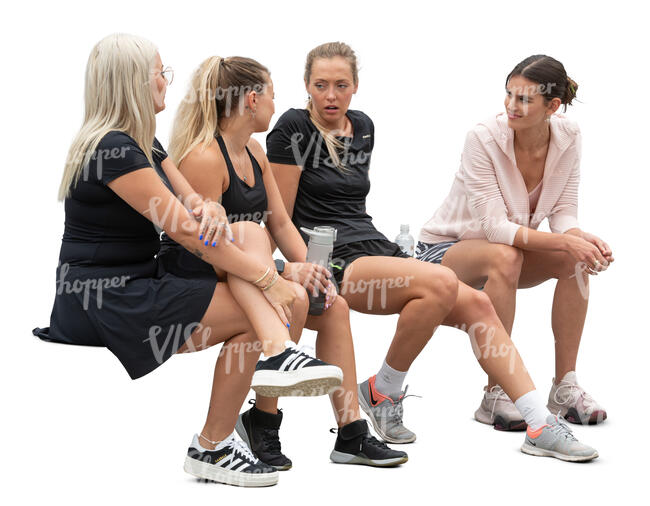 four sporty women sitting and talking after workout