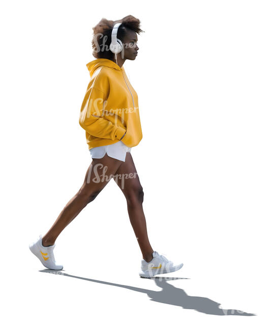 backlit black woman with headphones walking
