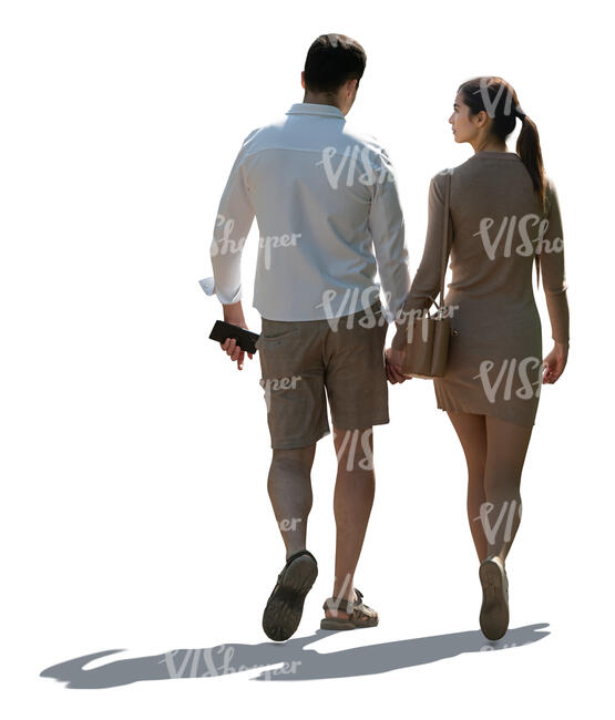 backlit couple walking hand in hand