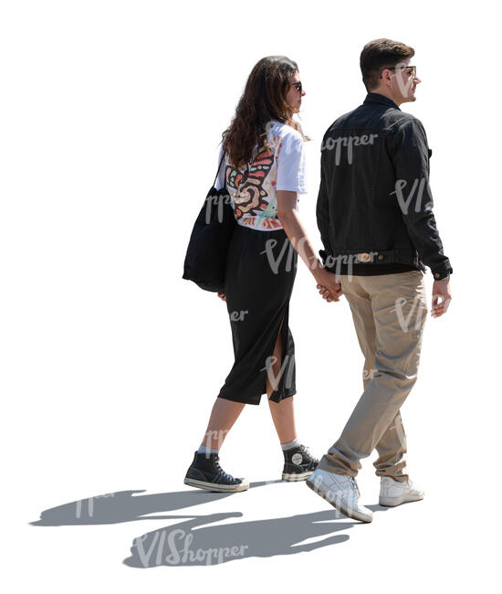 backlit man and woman walking holding hands