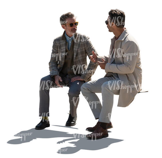 two backlit gentlemen sitting and talking