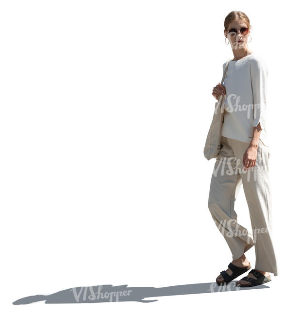 sidelit woman in relaxed white outfit walking