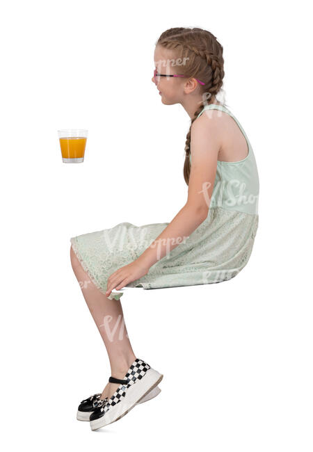 little girl sitting in a cafe and drinking juice