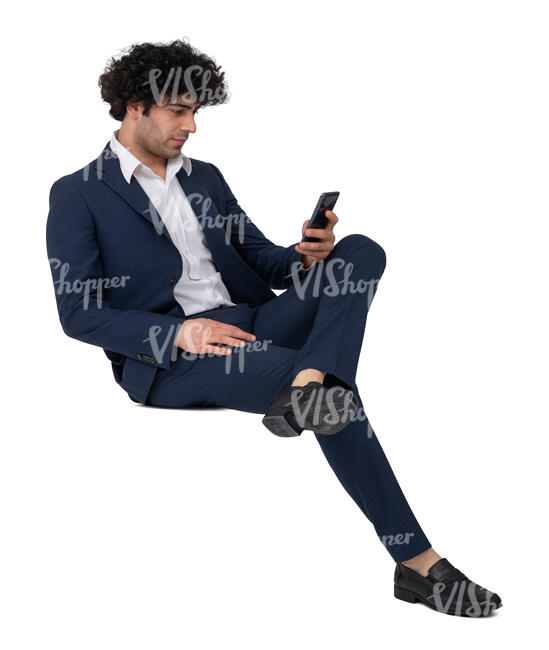man in a suit sitting and holding a phone