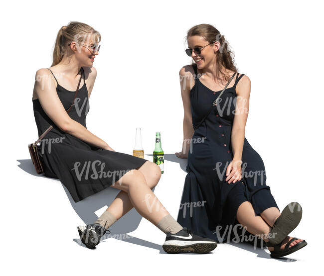 two women sitting outside and drinking