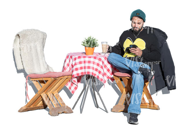 man sitting in an outdoor cafe on a sunny winter day