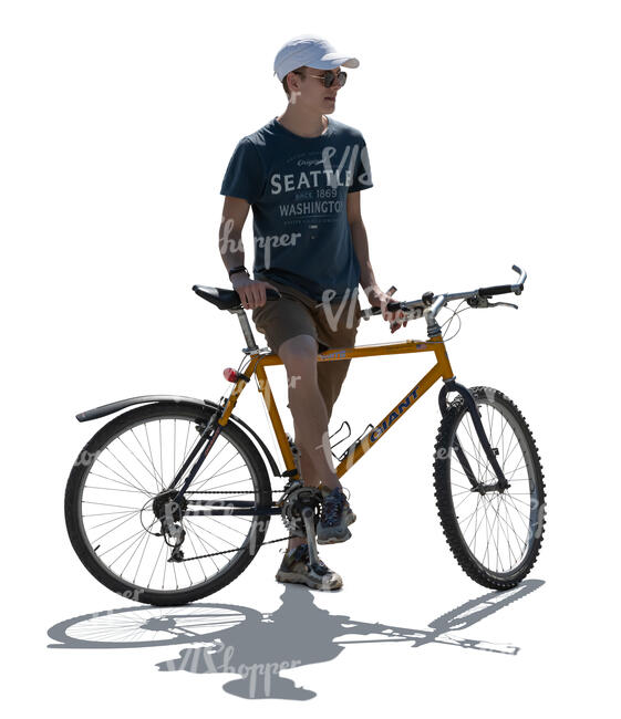 cut out backlit young man with a bike standing