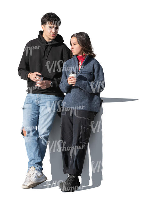 two people leaning against the wall and drinking coffee