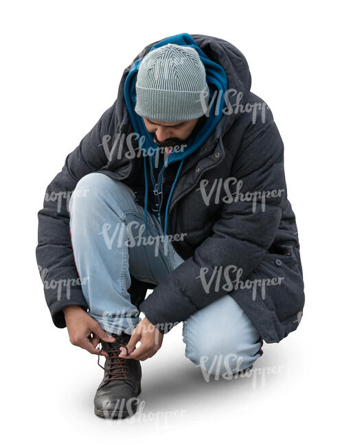 man squatting and tying his boot laces