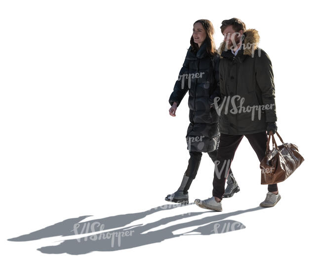 backlit man and woman walking on a sunny winter day