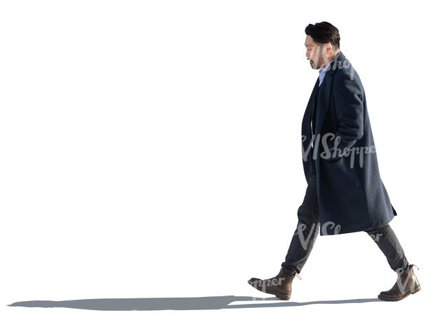backlit japanese man wearing an overcoat walking