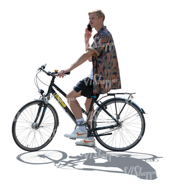 backlit man riding a bike and talking on a phone