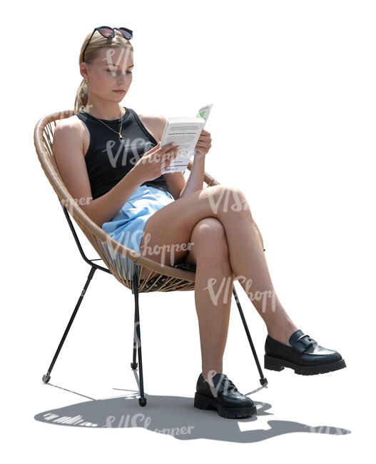 cut out backlit woman sitting on balcony chair and reading a book