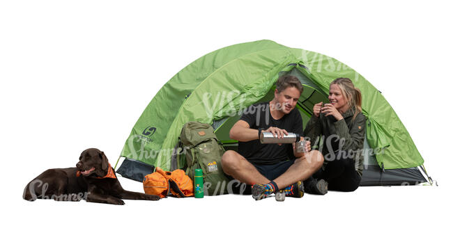 couple and a dog hiking and drinking tea in front of a tent