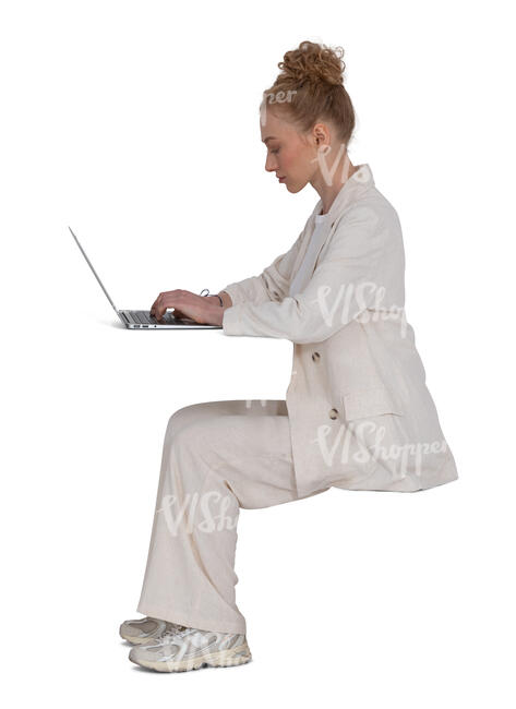 woman in a white suit sitting behind the desk and working with laptop