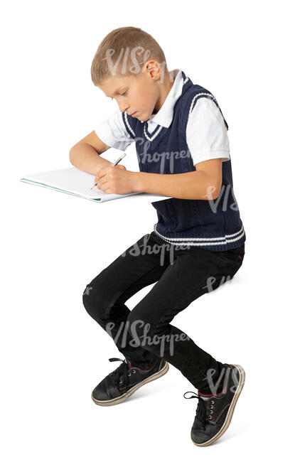 school boy sitting in class and writing