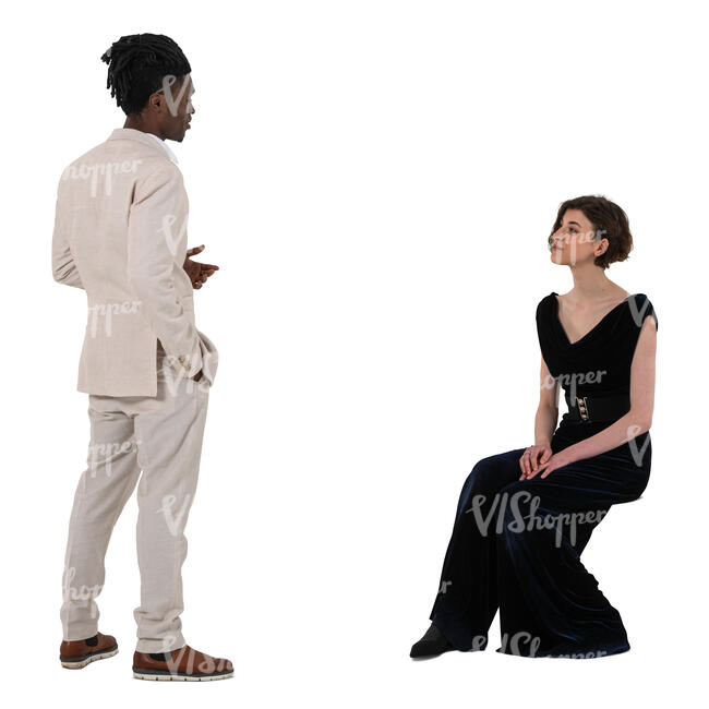man in a white suit talking to a woman sitting