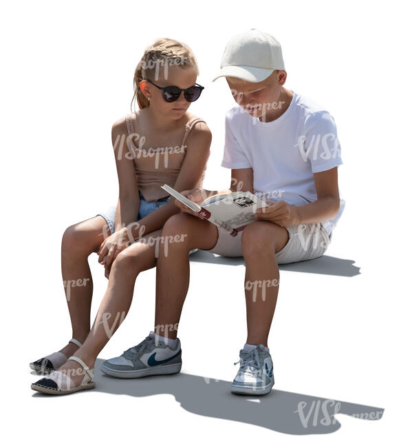 two children sitting and looking at a book