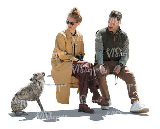cut out backlit man and woman sitting and looking at their dog