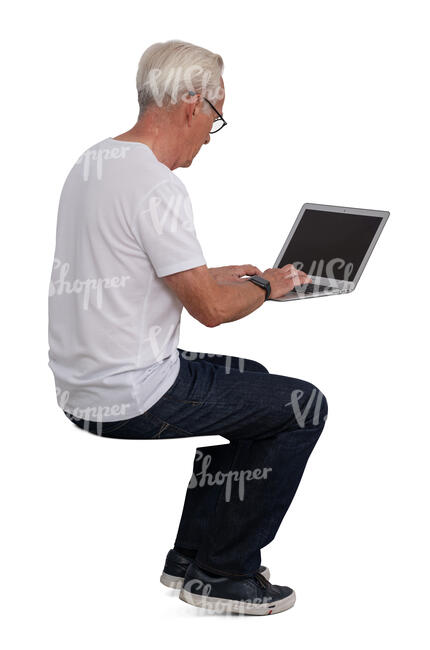 older gentleman sitting at a desk and working with a computer