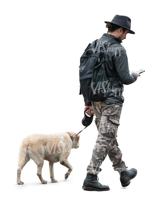 man walking with a dog and checking his phone