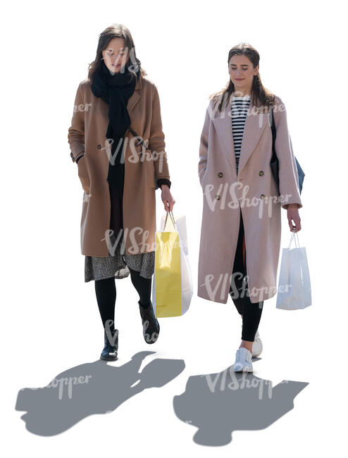 two backlit women with shopping bags walking
