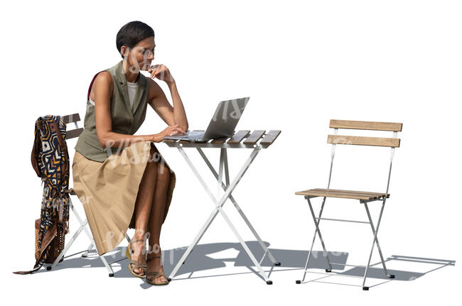 woman sitting outside behind the table with a laptop