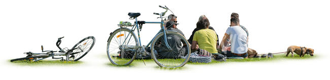 group of people with bikes and a dog sitting in a park on the grass