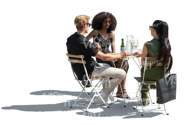 backlit group of three sitting in a restaurant