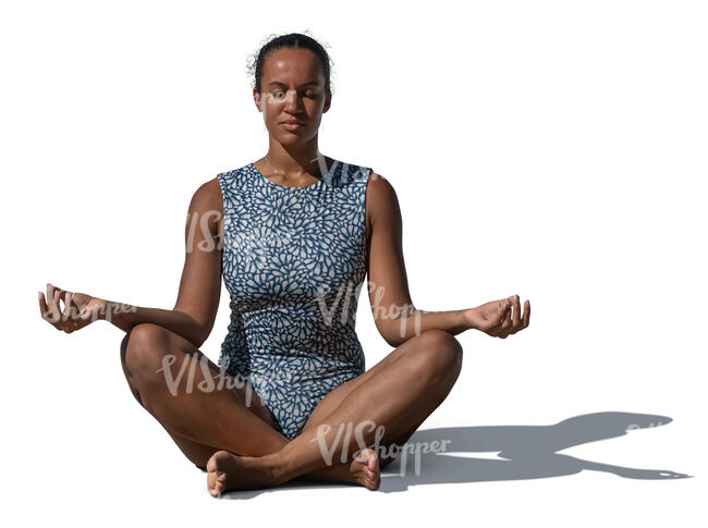 woman in a swimsuit sitting in a yoga pose outside in sunlight