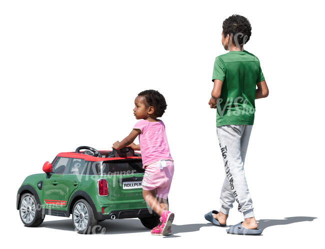 two cut out kids with a toy car walking