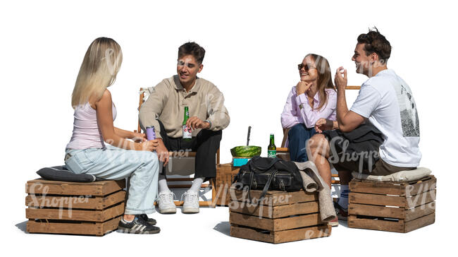 group of young people sitting outside and eating watermelon