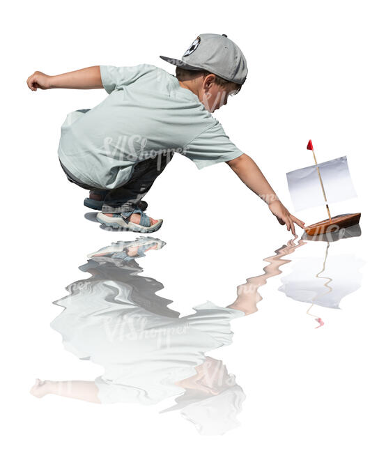 cut out little boy playing with a toy boat by the pond